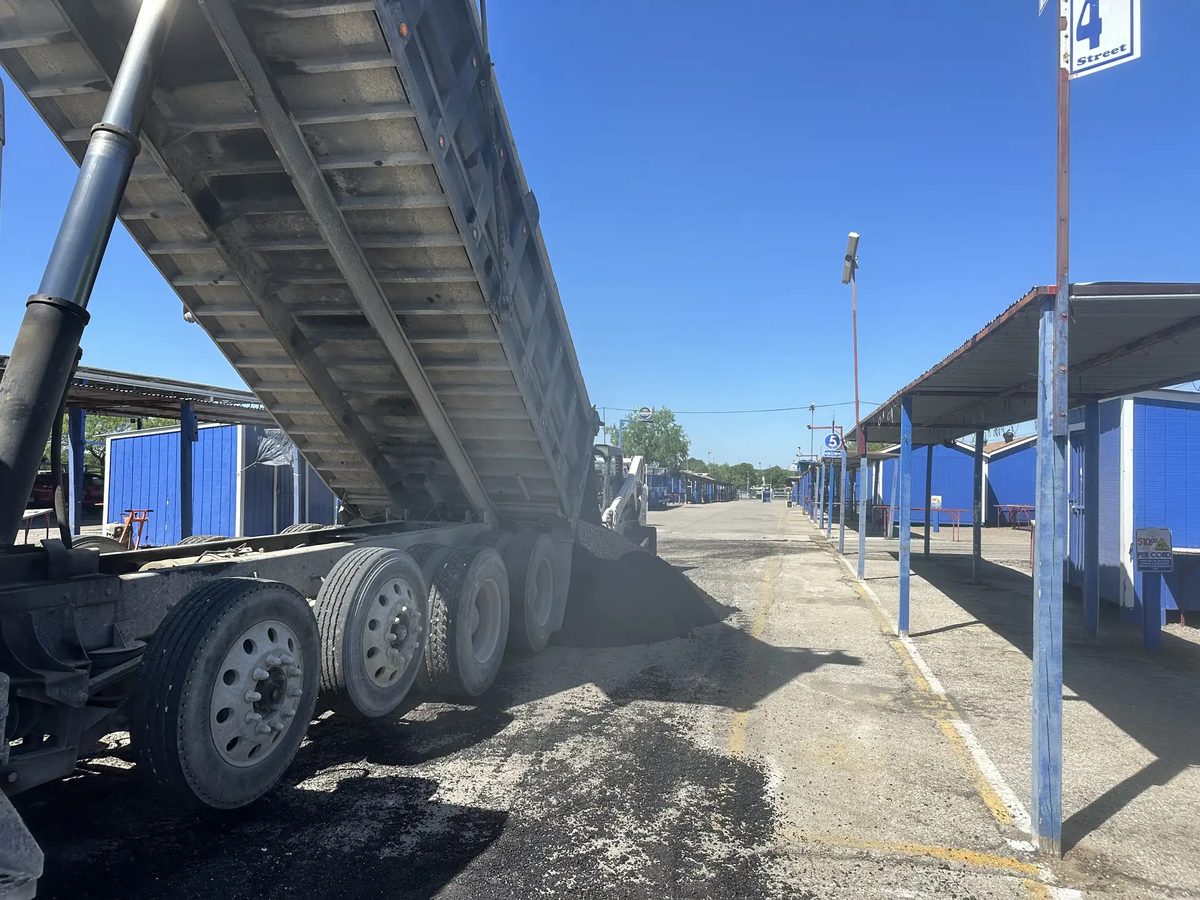 A Lonestar Construction Industries dump truck unloading base material at a job site in the San Antonio area